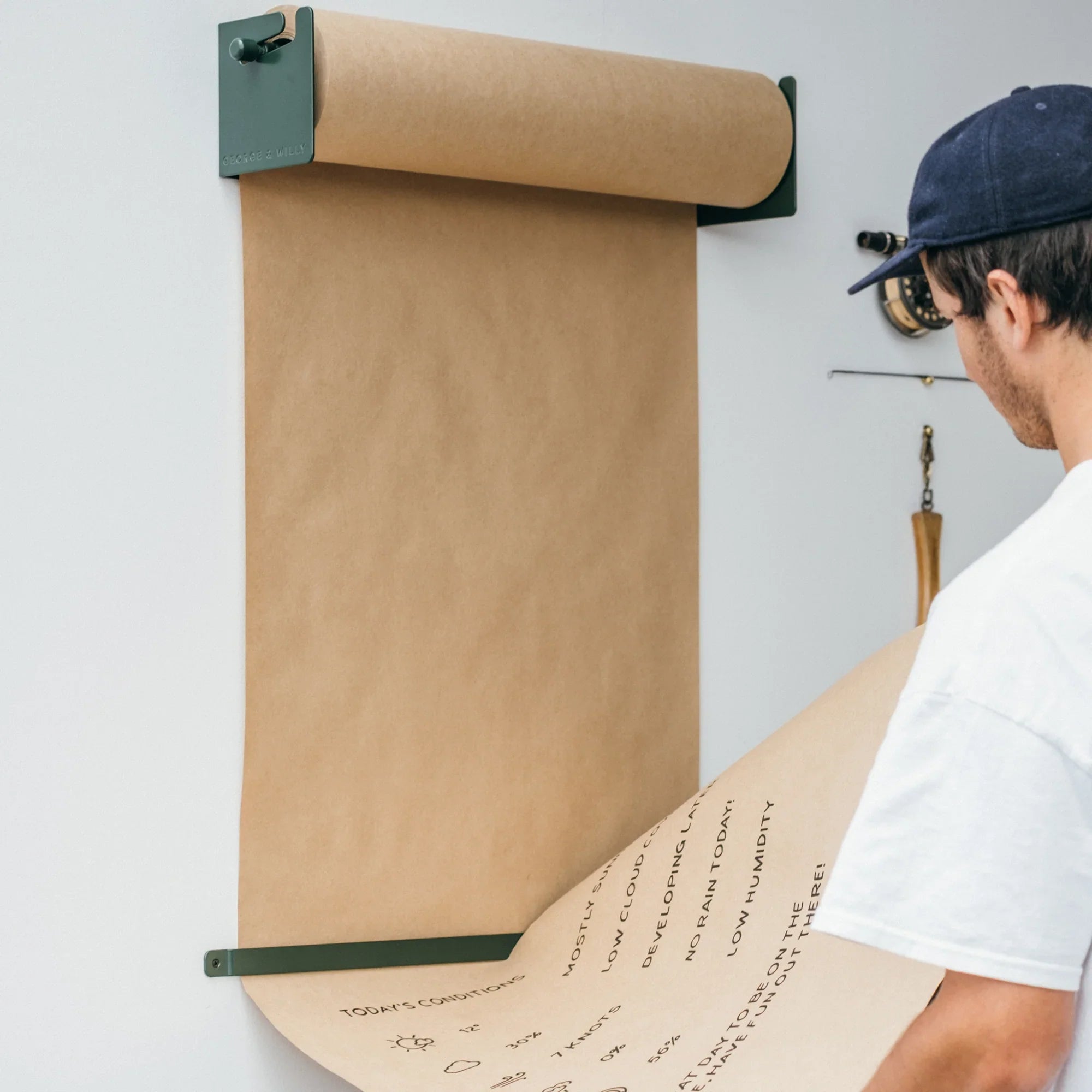Aluminum paper roll holder with man tearing kraft paper with text.