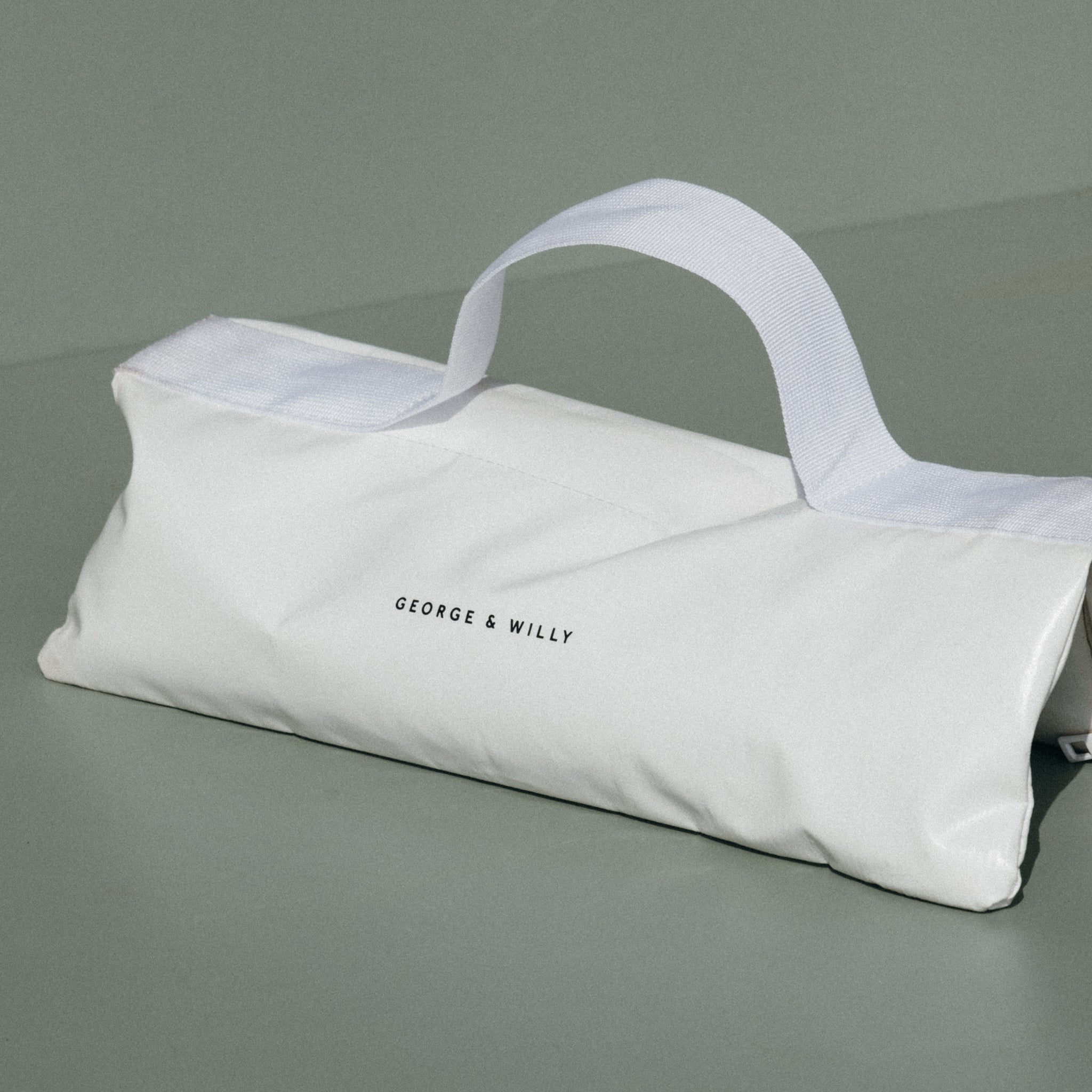 An empty white sandbag designed to weigh down an outdoor sign in windy conditions